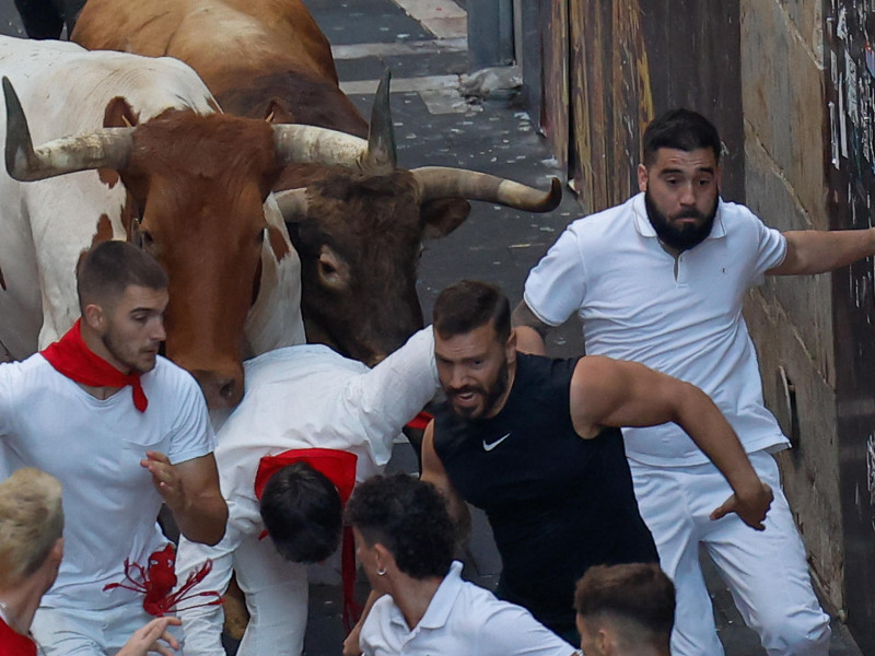 Los mozos son perseguidos por toros de la ganadería gaditana de La Palmosilla durante el séptimo encierro de los Sanfermines 2025 este domingo en Pamplona