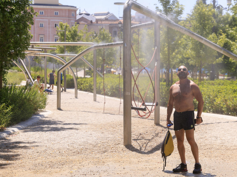 Un viandante se refresca en un difusor de agua situado en la Plaza de España este martes en Madrid