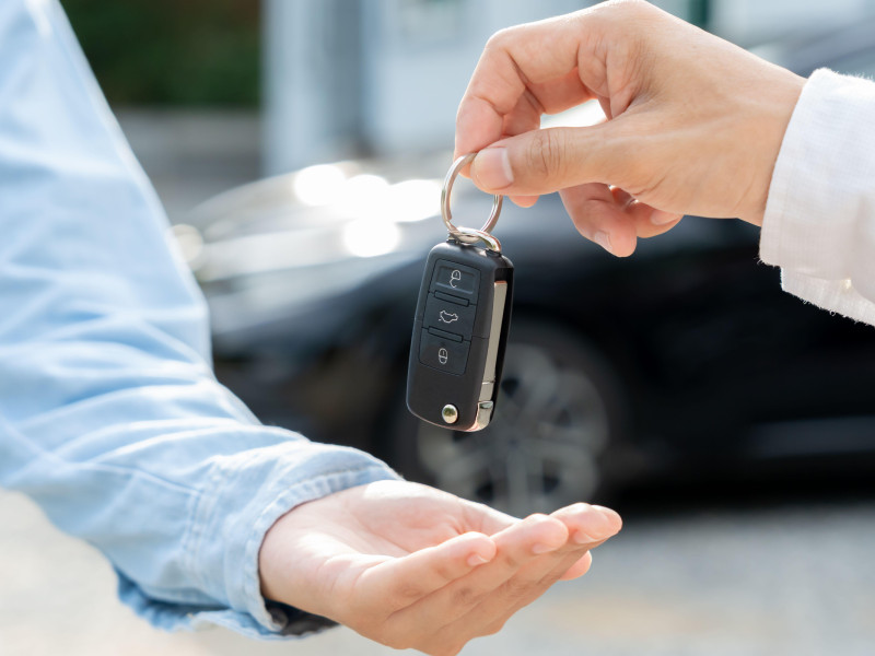 Una persona entrega las llaves del coche a otra