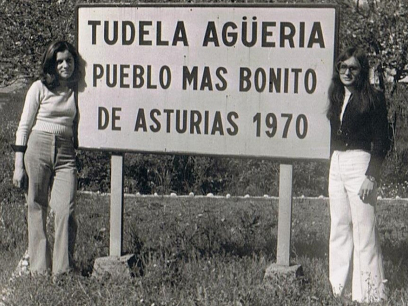 Dos vecinas junto a la señal que reconocía el galardón a Tudela Agüeria