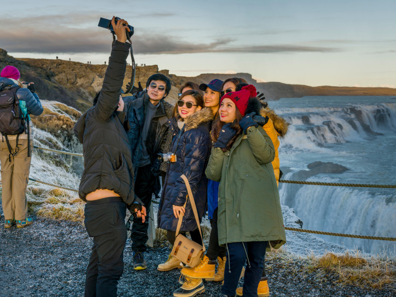 Turistas se toman fotos en las cataratas de Gullfoss, en Islandia