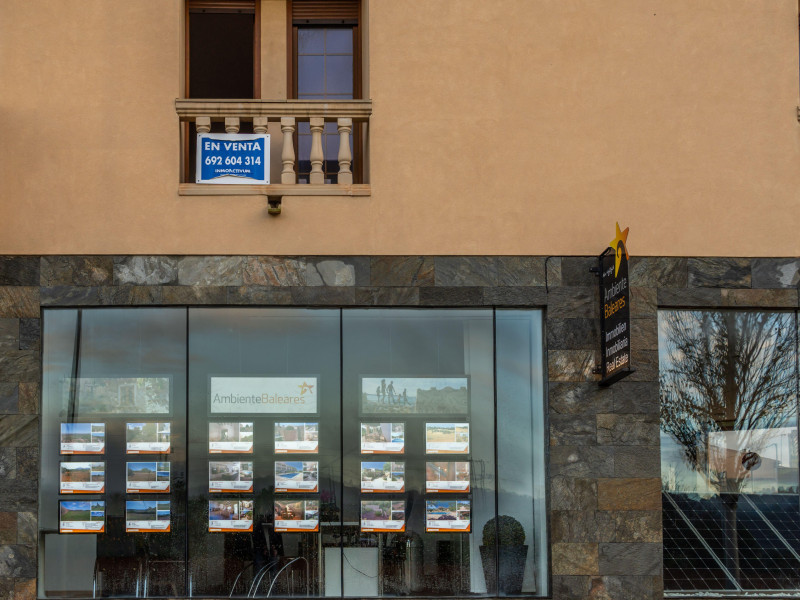 Escaparate de una agencia inmobiliaria con anuncios de pisos en venta en Mallorca.