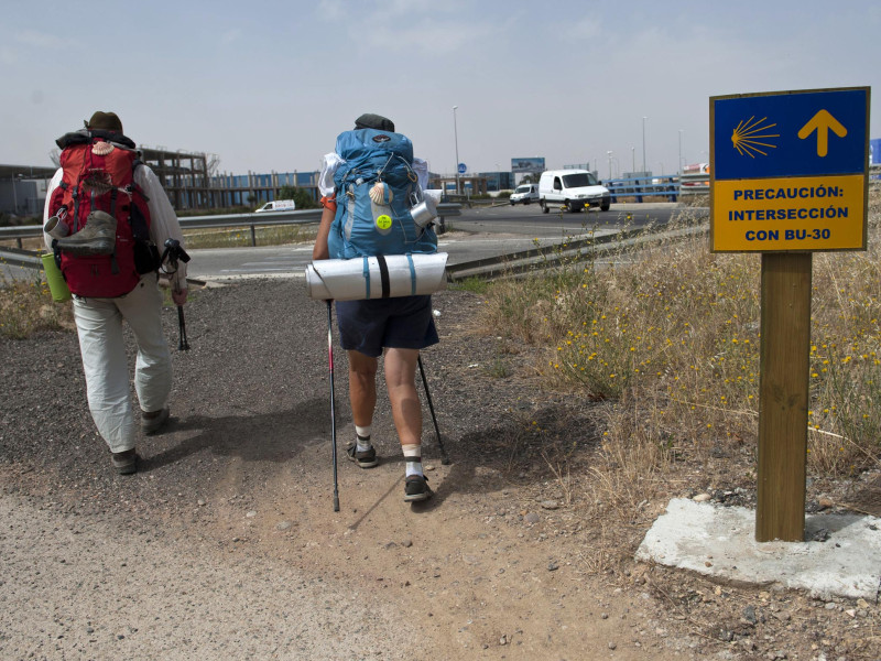 Dos peregrinos acceden a Burgos a través de la rotonda que intercede con la BU-30 con el Camino de Santiago