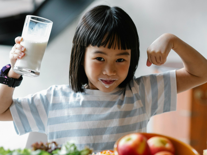 Una niña con un vaso de leche