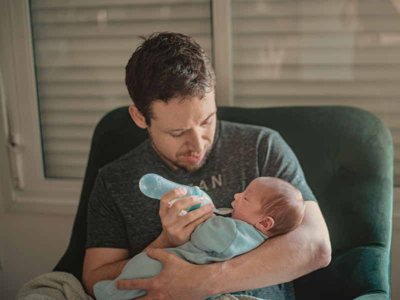 Un padre da de comer a su bebé