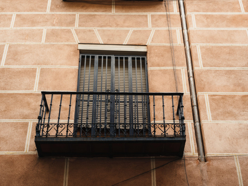 Vista en ángulo bajo de los tradicionales balcones de hierro fundido de un antiguo edificio residencial en el barrio de Lavapiés, en el centro de Madrid, víctimas de okupas