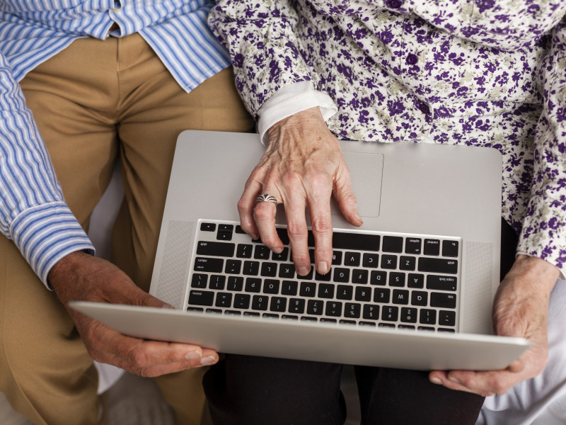 Una pareja mayor consulta internet desde un ordenador portátil