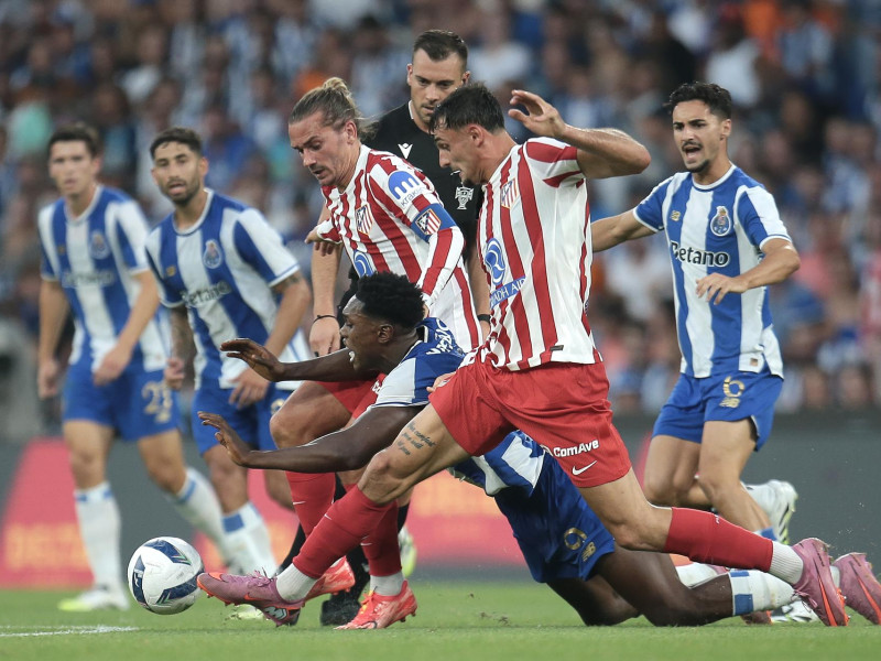 Samu (C) del FC Porto en acción contra Griezman (D) del Atlético de Madrid durante su partido amistoso de fútbol celebrado en el Estadio Dragao en Oporto, Portugal.