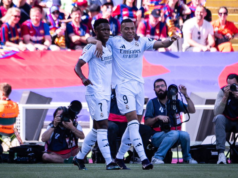 Kylian Mbappé del Real Madrid celebra un gol con su compañero Vinicius Junior durante el partido de la Primera División española entre el FC Barcelona y el Real Madrid CF en el Estadi Olimpic Lluis Companys.