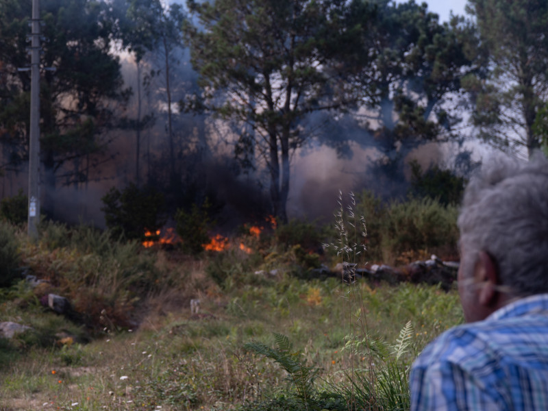 Una persona observa el fuego en Ponteceso, A Coruña, Galicia