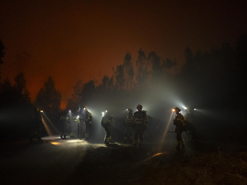 Un grupo de bomberos trabajan para extinguir un incendio forestal este miércoles, en As Neves, Pontevedra