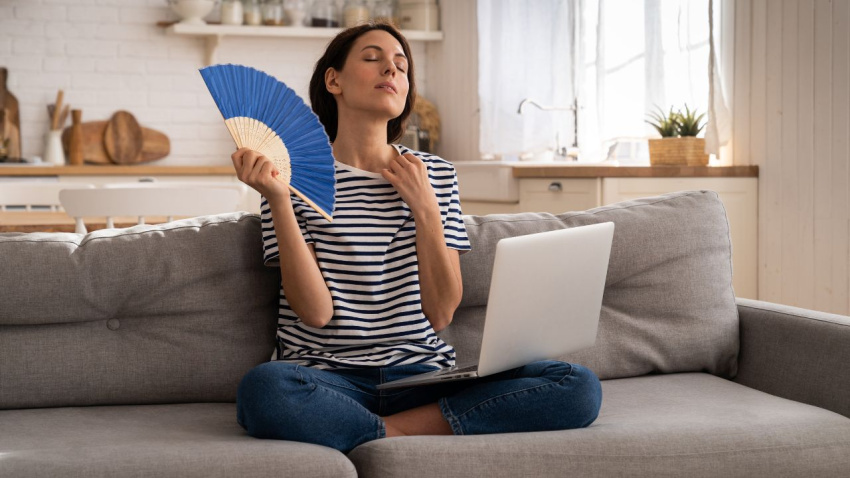 Chica con calor en casa abanicándose