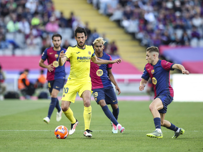 Dani Parejo (Villarreal CF) controla el balón mientras es defendido por Lamine Yamal (FC Barcelona) y Fermín López (FC Barcelona) durante el partido de LaLiga entre FC Barcelona y Villarreal CF en el Olímpic Lluís Companys, el 18 de mayo de 2025 en Barcelona, España.