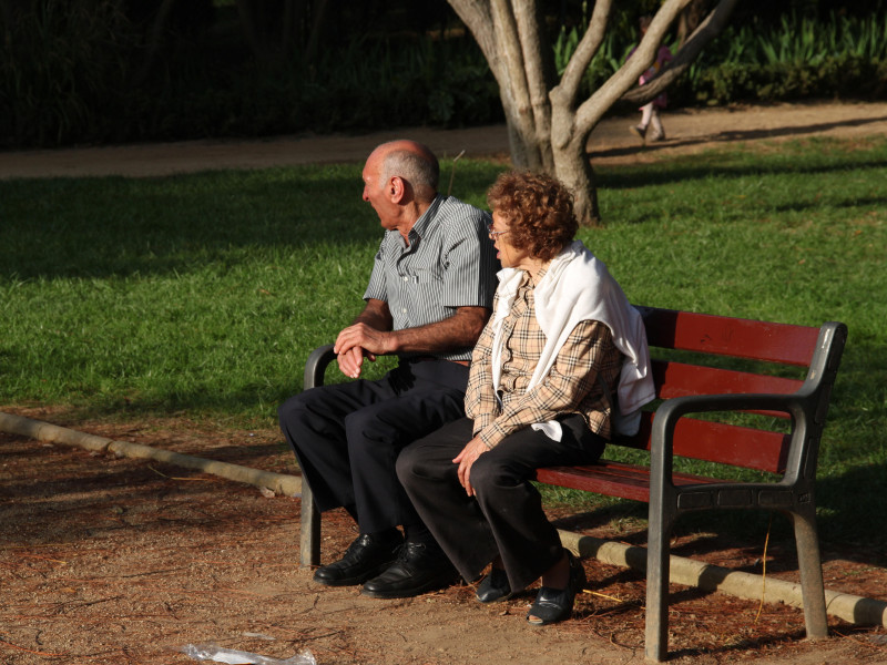 Pareja de jubilados sentados en un banco del parque, Montjuic, Barcelona