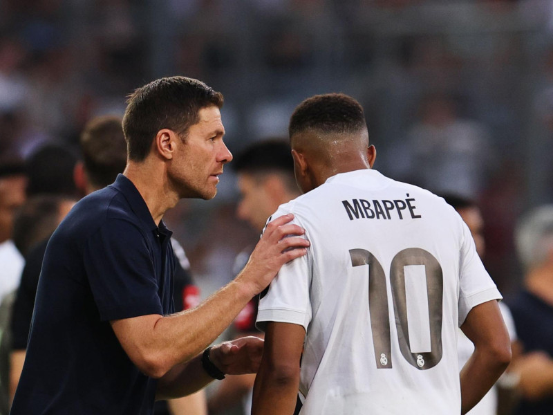El entrenador del Real Madrid, Xabi Alonso (izq.), habla con el jugador Kylian Mbappé durante un partido amistoso entre el WSG Tirol y el Real Madrid, en Innsbruck, Austria, el 12 de agosto de 2025.