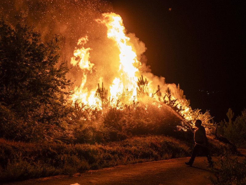 Un vecino colabora en las labores de extinción del incendio forestal en Carballeda de Avia (Ourense)