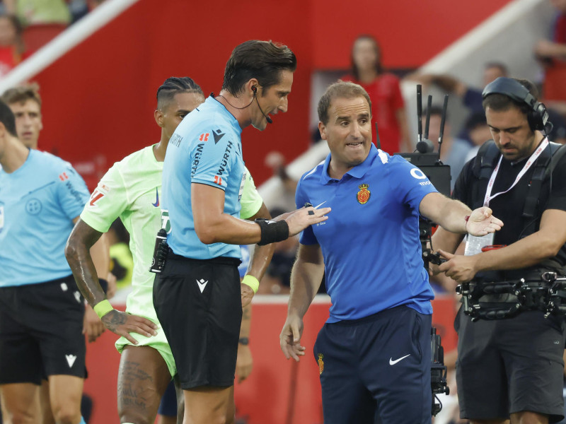 El árbitro del encuentro José Luis Munuera (c) conversa con el entrenador del Mallorca, Jagoba Arrasate (2d), tras el segundo gol del Barcelona este sábado, durante la primera jornada de LaLiga EA Sports, entre el RCD Mallorca y el FC Barcelona, en el estadio de Son Moix de Palma de Mallorca