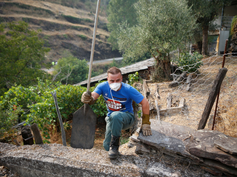 Pie de Foto:Voluntarios trabajar para evitar que el fuego se acerque al pueblo, a 17 de agosto de 2025, en Quiroga, Lugo