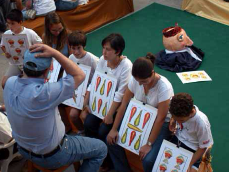 Los niños hacen de cartas en la partida de guiñote viviente de Olba
