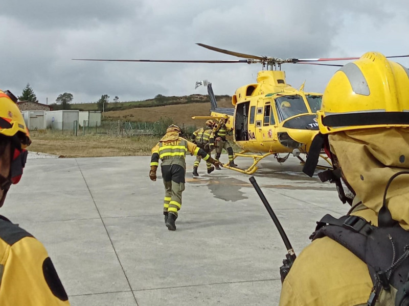 Bomberos de la BRIF de Tineo dirigiéndose al helicóptero