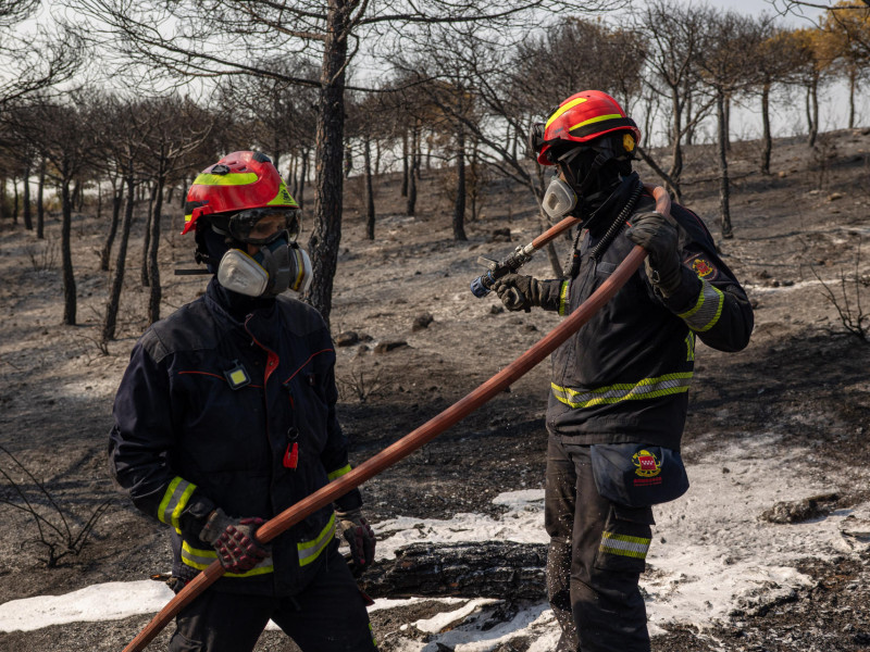 Bomberos enfrían un área de superficie quemada por el incendio en Colmenar Viejo