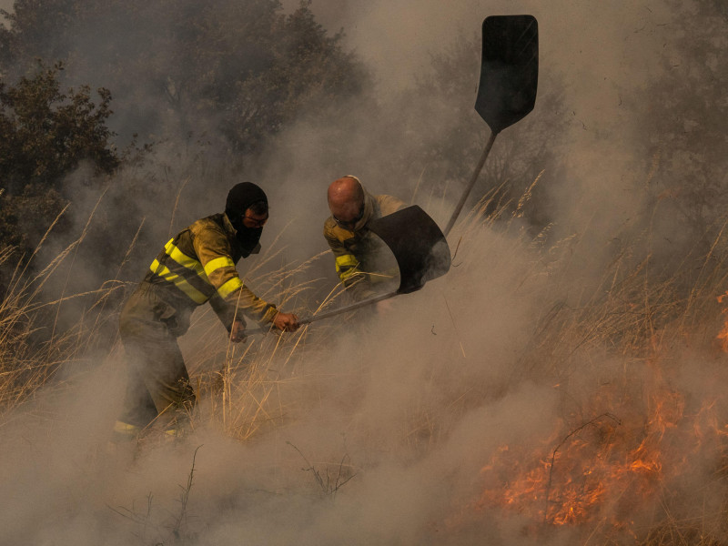 Dos voluntarios realizan labores de extinción en el incendio de Oímbra (Ourense)