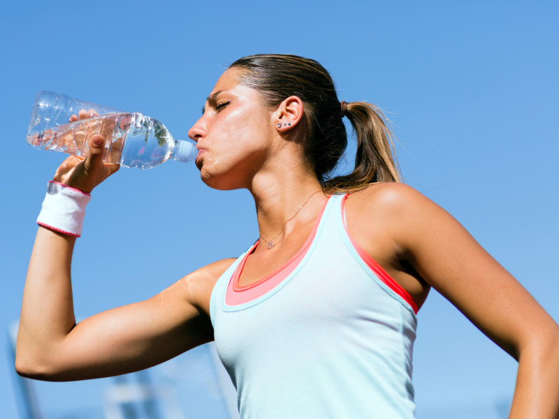 Una joven bebiendo agua después de hacer deporte