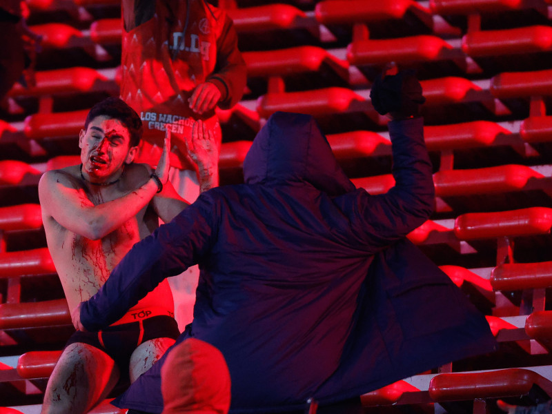 Hinchas argentinos golpean a los chilenos en una de las tribunas.