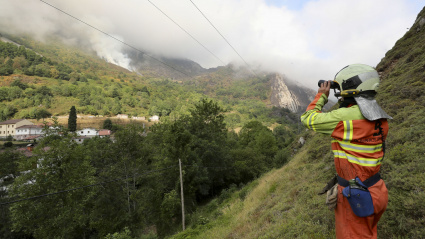 Un bombero observando uno de los incendios que están cerca de lun núcleo de viviendas en Asturias