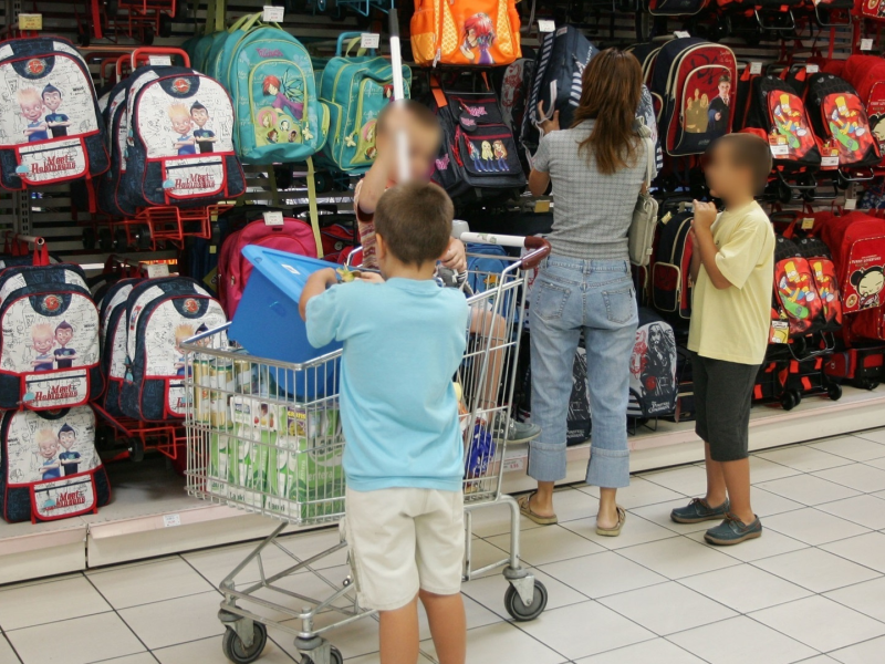 Una madre y sus dos hijos compran material escolar en plena vuelta al cole