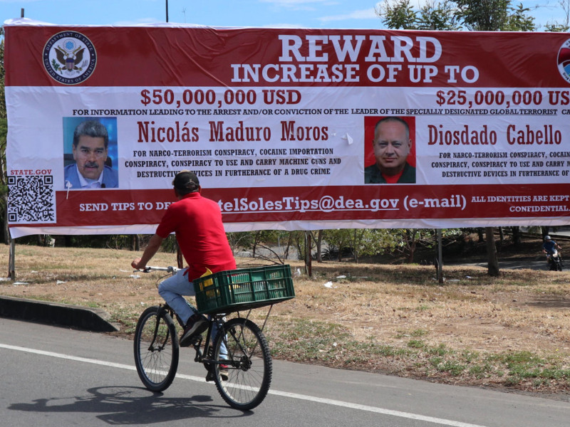 Un hombre observa una valla con la imagen del presidente de Venezuela, Nicolás Maduro, y del ministro de Relaciones Interiores, Justicia y Paz de Venezuela, Diosdado Cabello, este sábado en Villa del Rosario (Colombia)