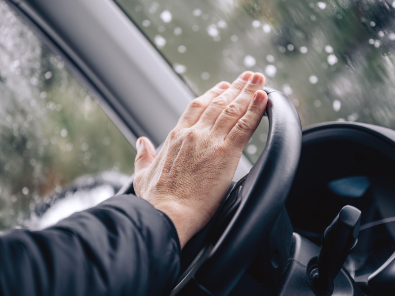 Bocina de coche, mano masculina en el volante del coche