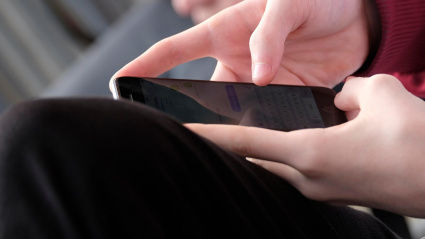 Joven escribe en su teléfono móvil