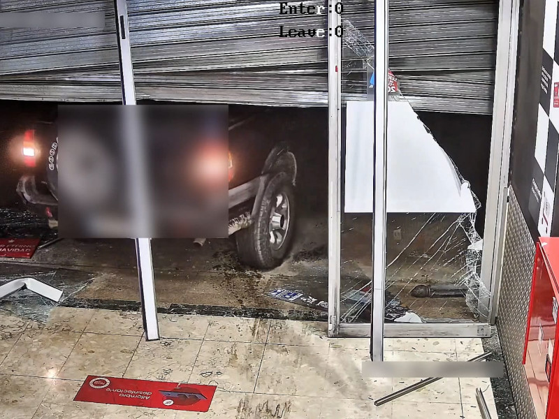 Momento en el que los ladrones empotraron su vehículo contra la puerta de un local.