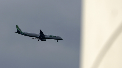 Un avión sobrevuela el Centro Niemeyer de Avilés, acercándose al aeropuerto de Asturias