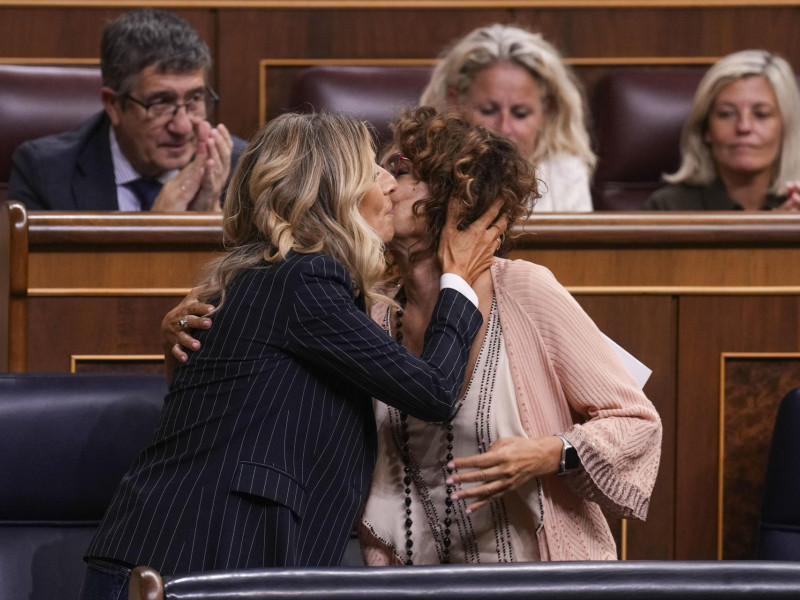 La ministra de Hacienda, María Jesús Montero (d) y la ministra de Trabajo, Yolanda Díaz, se saludan durante el debate para la reducción de la duración máxima de la jornada ordinaria de trabajo, este miércoles en el Pleno del Congreso de los Diputados