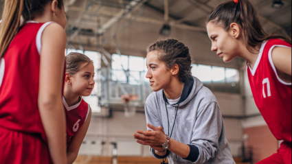 Entrenadora de un equipo de baloncesto con sus jugadoras