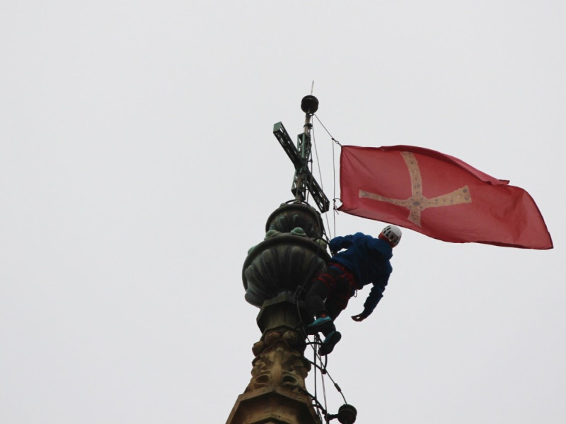 Colocación de las banderas del Jubileo en lo alto de la Catedral de Oviedo