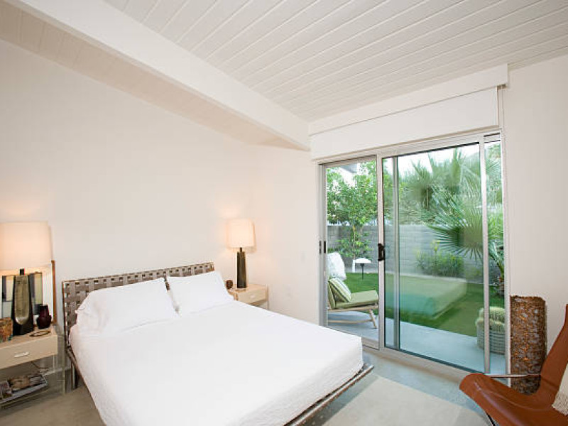 Lit lamps by bed in bedroom with view of porc
