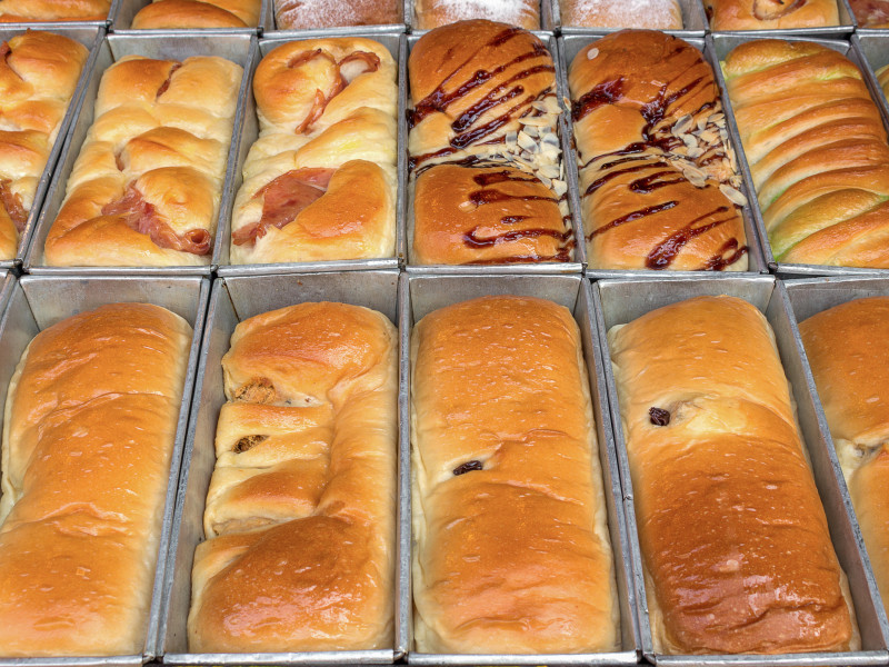Pan recién horneado en bandeja del horno de una panadería moderna