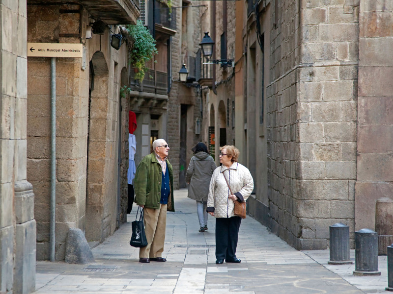 Una pareja de jubilados haciendo compras en un callejón del Barri Gòtic de Barcelona