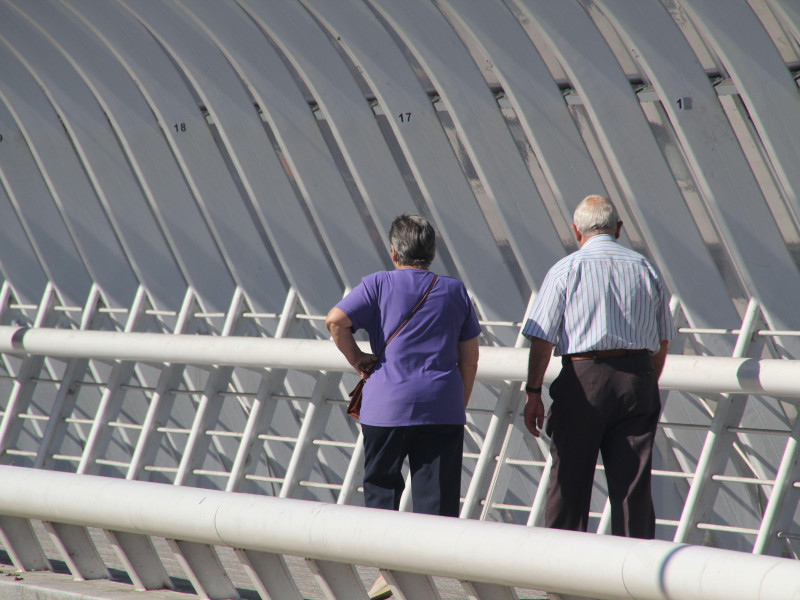 Una pareja de jubilados caminando por un puente moderno en Bilbao