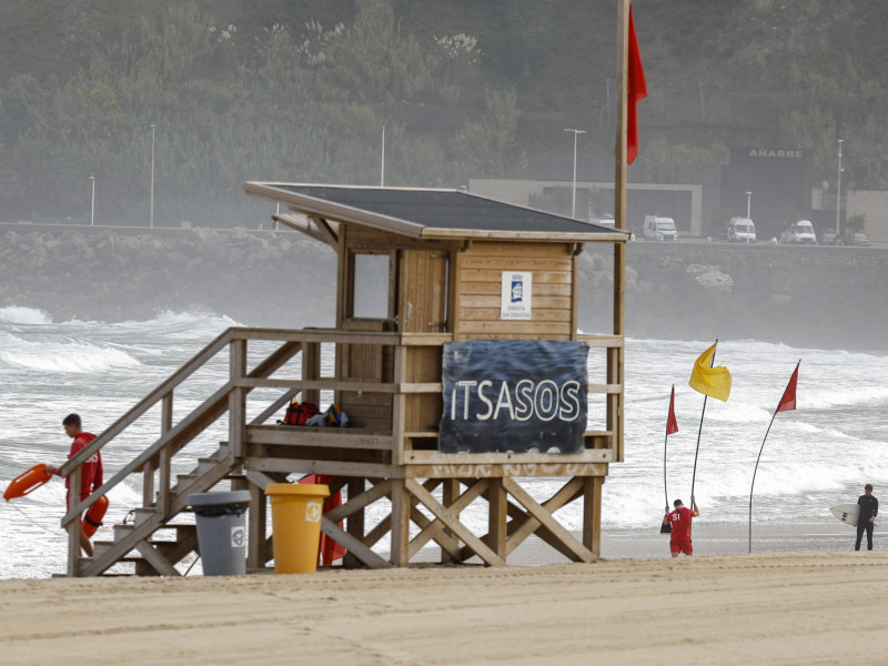 Unos socorristas señalizan la zona de baño en la playa de la Zurriola de San Sebastián
