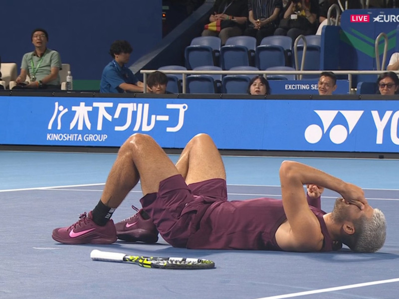 Carlos Alcaraz se duele en el suelo después del problema en el tobillo sufrido en Tokio.