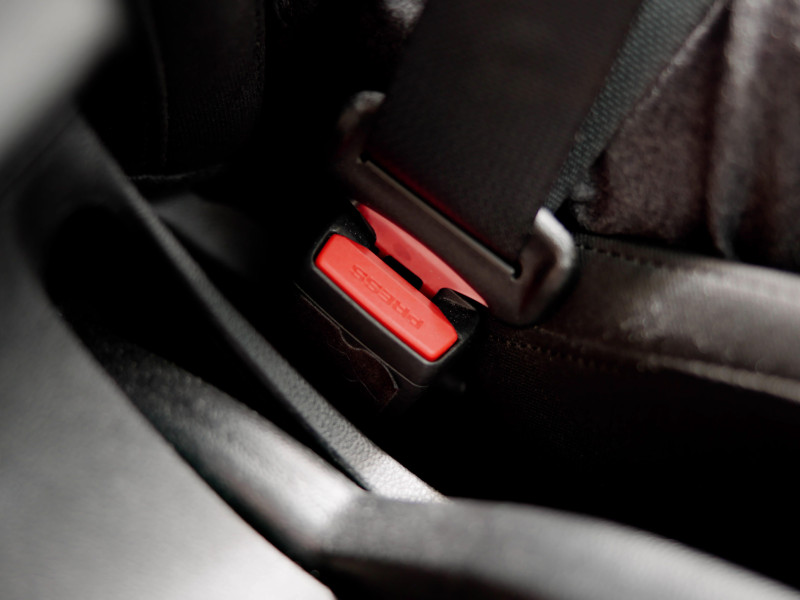 Una mujer sostiene la hebilla del cinturón de seguridad en el interior del coche.