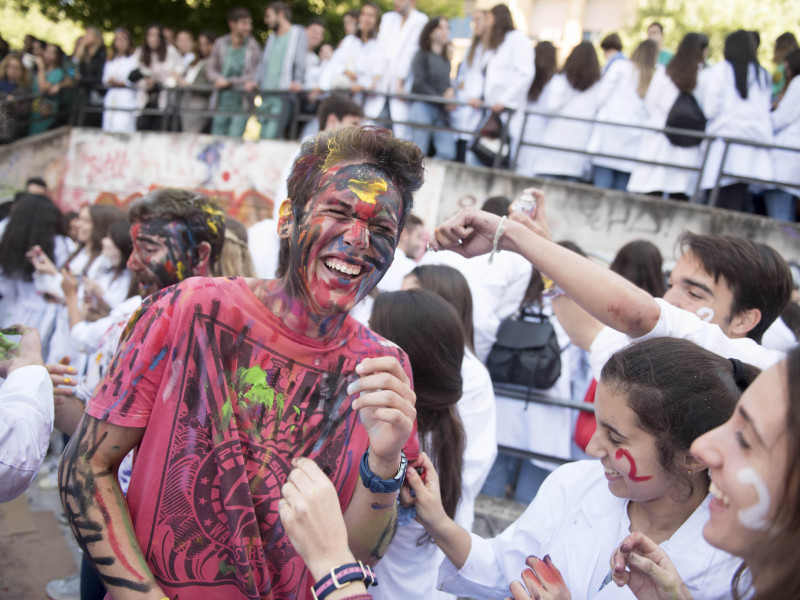 Un estudiante de medicina es visto sonriendo después de ser pintado por sus compañeros durante las novatadas.