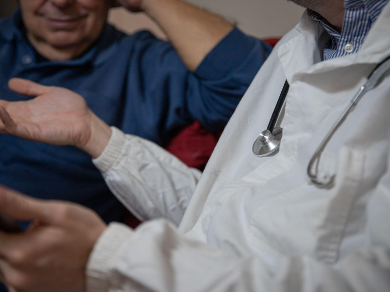 Primer plano del estetoscopio de un médico durante una visita a un paciente mayor