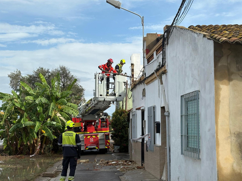 Bomberos trabajando en la fachada de la vivienda