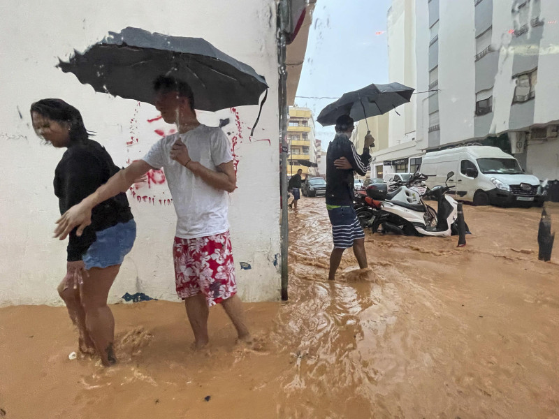 Personas caminan por calles anegadas en Ibiza debido a las intensas lluvias