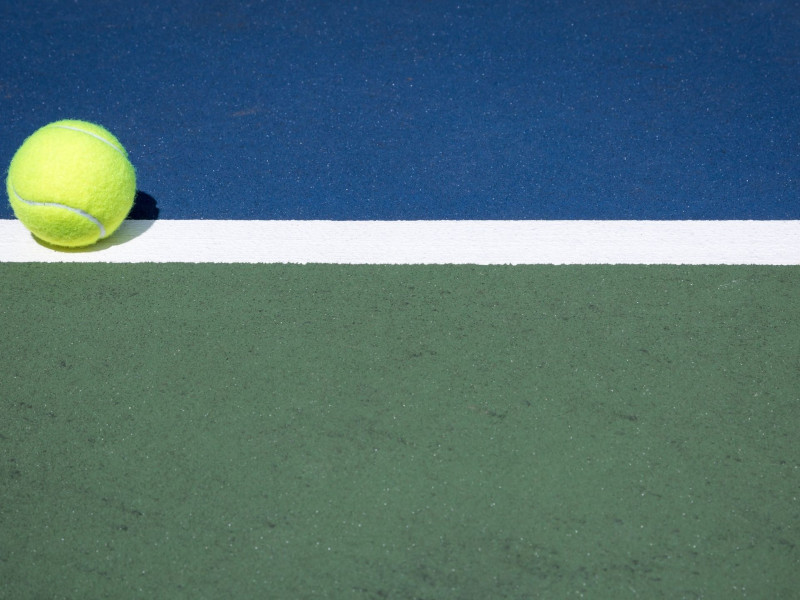 Bote de una pelota de tenis en un partido jugado en pista dura